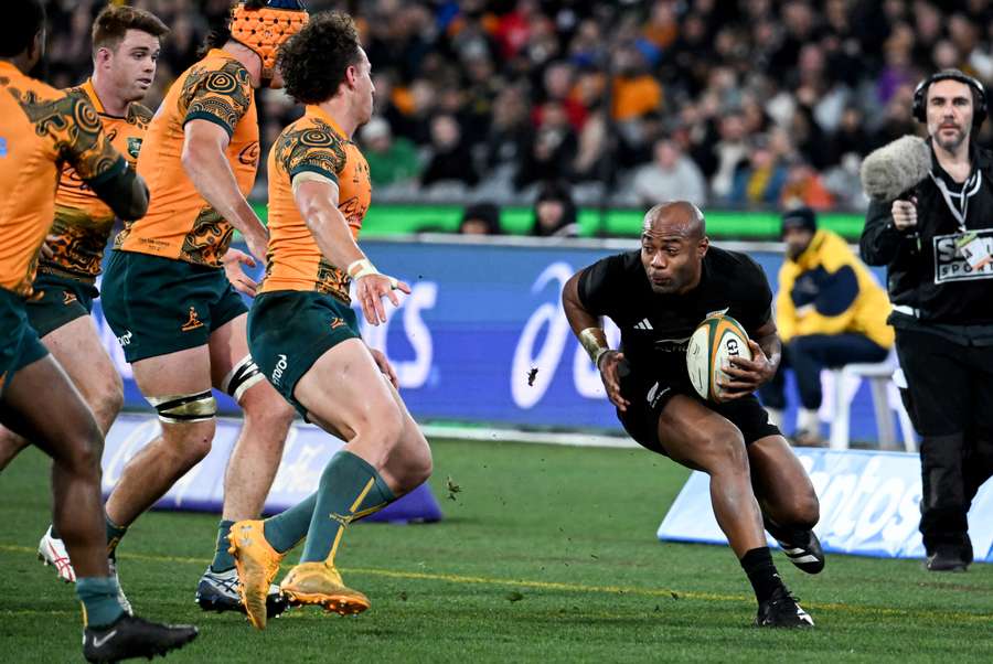New Zealand's Mark Telea (R) evades the Australian defence during the Rugby Championship