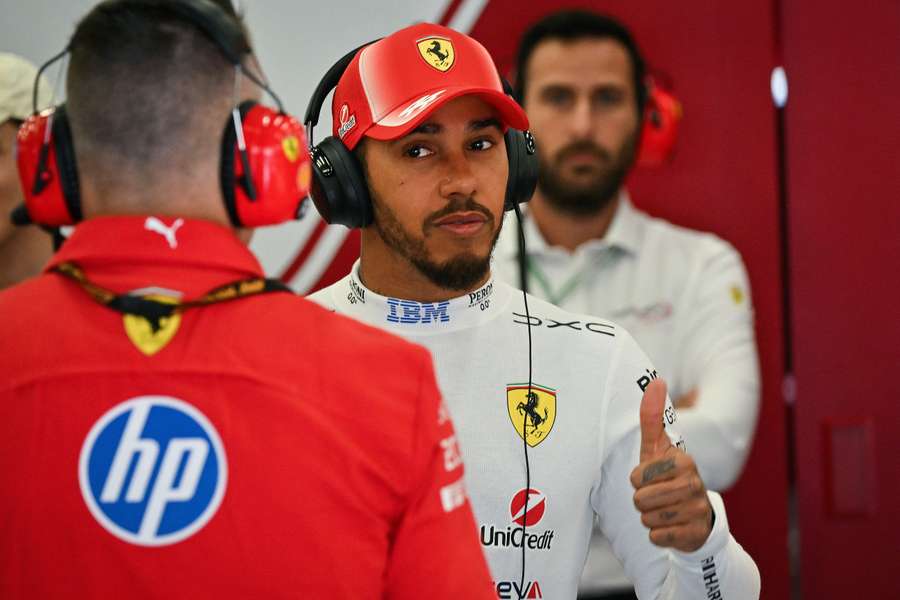 Lewis Hamilton gives a Ferrari mechanic the thumbs up in the Spa-Francorchamps pits