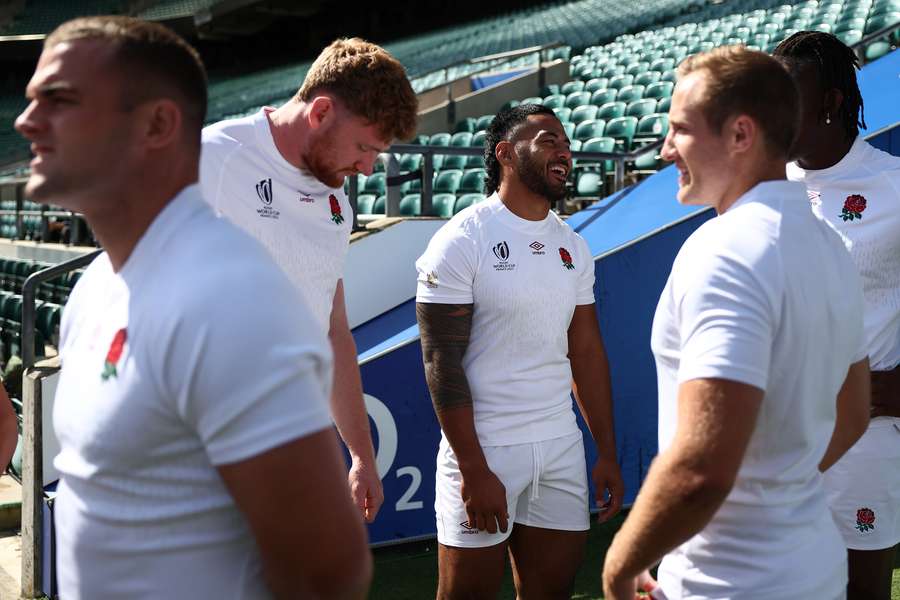 Manu Tuilagi jokes with teammates as they wait to pose for a group photo