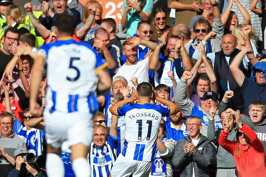 Brighton's Belgian midfielder Leandro Trossard (C) celebrates with fans after scoring the opening goal 