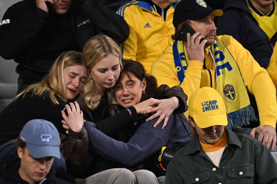 De svenske fans trøster hinanden inde på stadion.