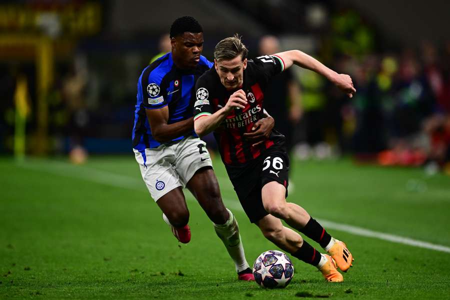 AC Milan's Belgian forward Alexis Saelemaekers (R) challenges Inter Milan's Dutch midfielder Denzel Dumfries