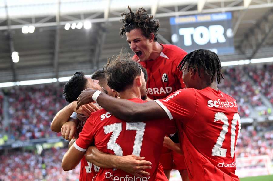 Freiburg's players celebrate after scoring their third goal