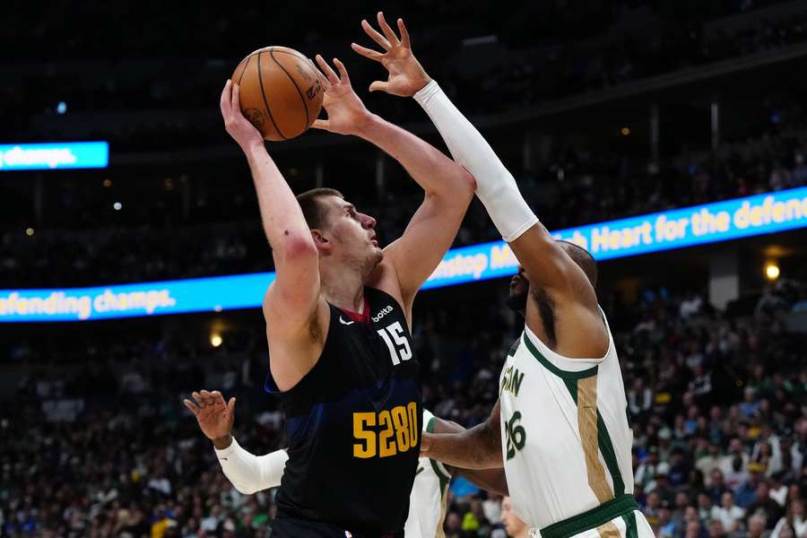 Jokic (L) leaps with the ball