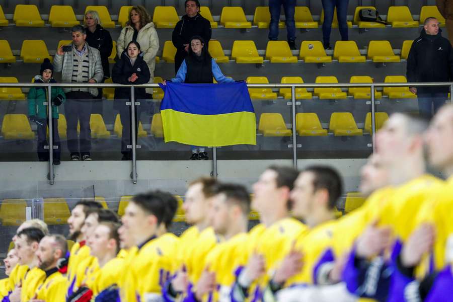 Een Oekraïense fan houdt een vlag vast tijdens het volkslied voor een vriendschappelijke wedstrijd tussen Oekraïne en Hongarije