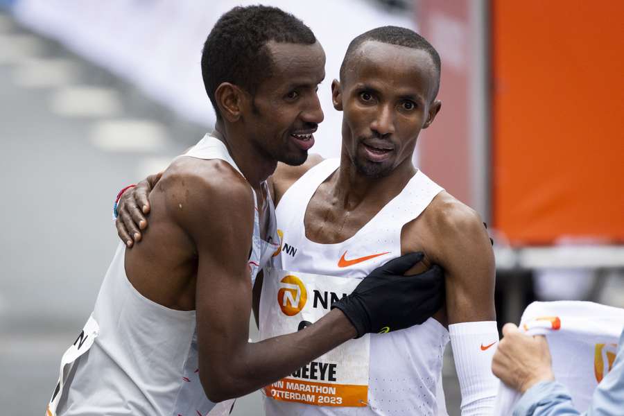 Winnaar Bashir Abdi (L) omhelst Abdi Nageeye na de finish