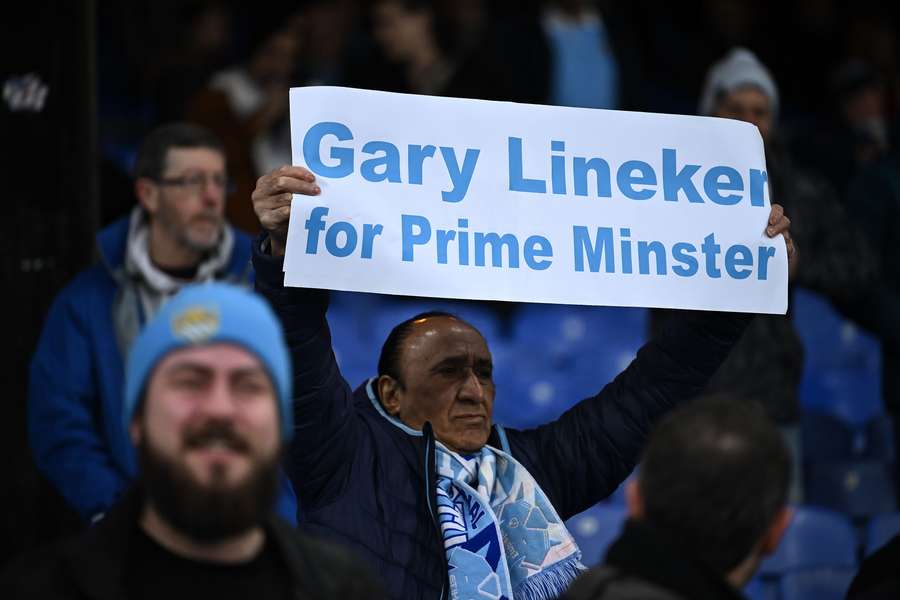 A Manchester City fan holds a banner reading 