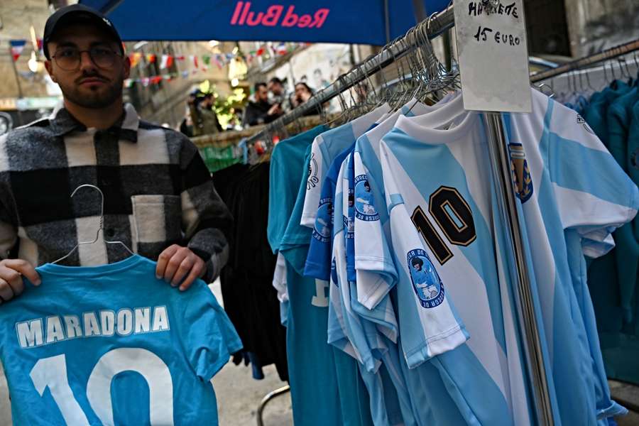 A vendor displays T-shirts bearing name of the late Argentine football legend Diego Maradona at the Via Emanuele De Deo Spanish quarter in central Naples