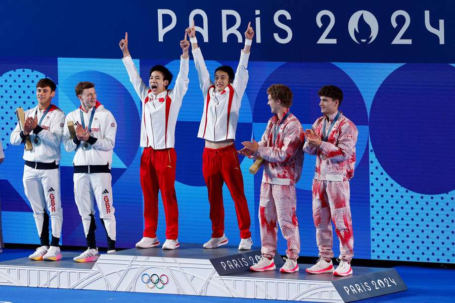 Gold medallists Junjie Lian and Hao Yang react on the podium