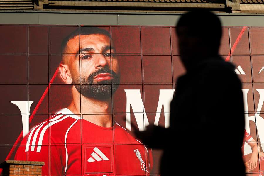 A fan walks past an image of Mohamed Salah 