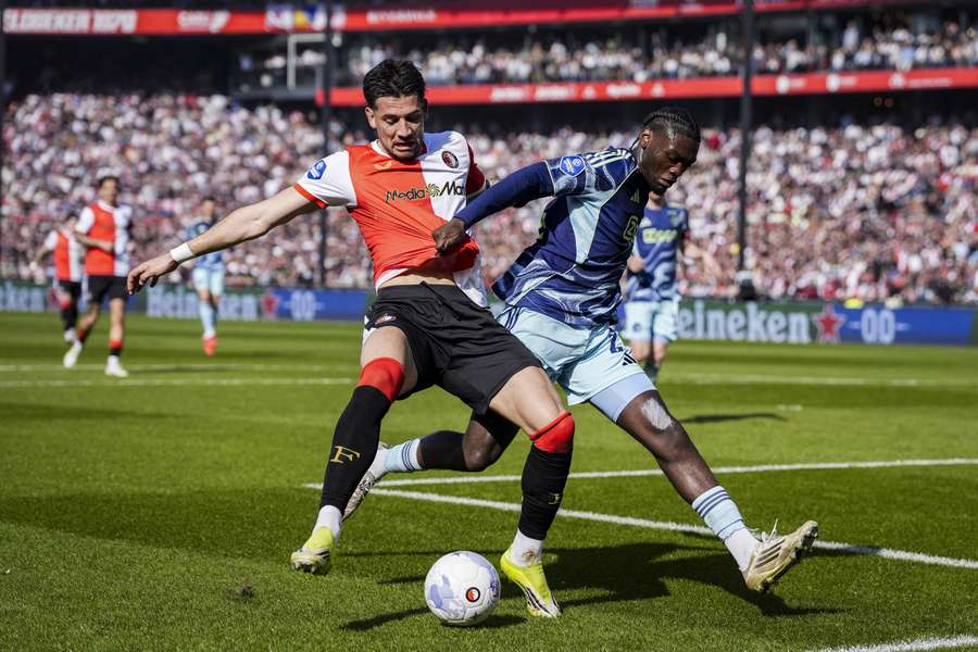 Feyenoord's Luciano Valente shields the ball from Ajax midfielder Jorthy Mokio