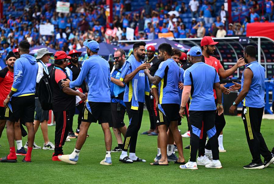 India and Canada team members shake hands after their T20 World Cup group match was abandoned