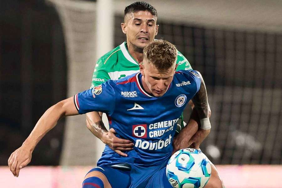 Mateusz Bogusz (z przodu) z Cruz Azul walczy o piłkę z Javierem Guemezem z Santos podczas meczu piłkarskiego Liga MX Apertura.
