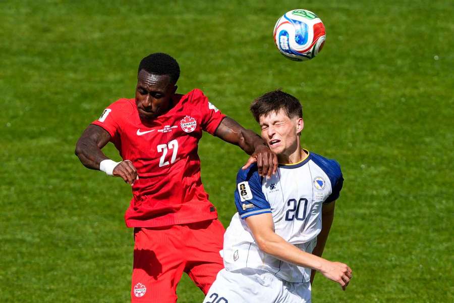 Kanaďan Richie Laryea s hlavičkovém souboji s Esmirem Bajraktarevičem z Bosny a Hercegoviny.