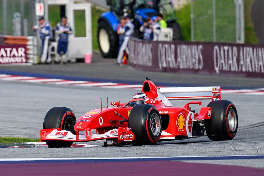 Gerhard Berger drives a Ferrari of German former racing driver Michael Schumacher as he takes part in the Legends Parade