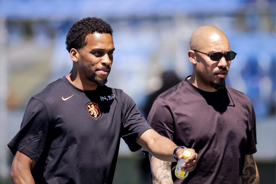 Jurrien Timber walks alongside Netherlands technical director Nigel de Jong