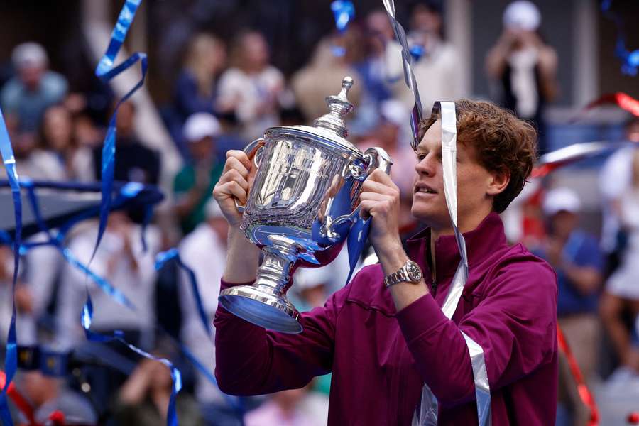 Jannik Sinner holds the men's singles trophy in 2024