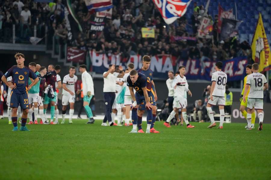 Roma players stand dejected at the end of the match