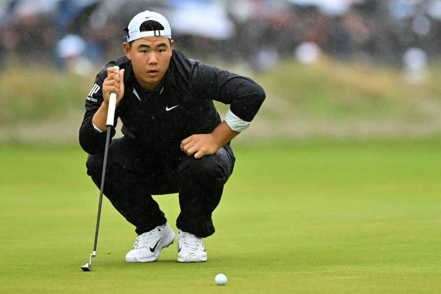 Tom Kim lines up a putt on the 18th green on day four of the British Open Championship