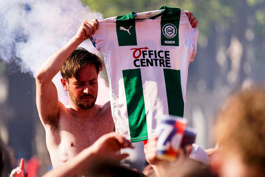 A PSV fan holds up an FC Groningen jersey during the title celebrations in Eindhoven A PSV fan holds up an FC Groningen jersey during the title celebrations in Eindhoven