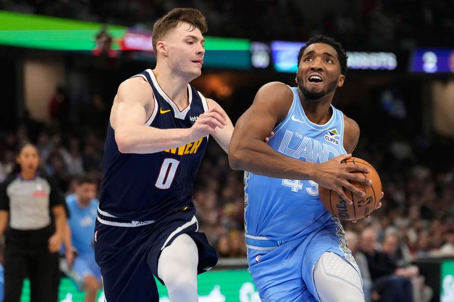 Cleveland Cavaliers guard Donovan Mitchell (R) drives against Denver Nuggets guard Christian Braun