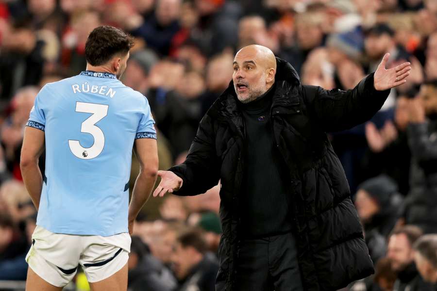 Pep Guardiola speaks to Manchester City's Ruben Dias after Liverpool scored their second goal