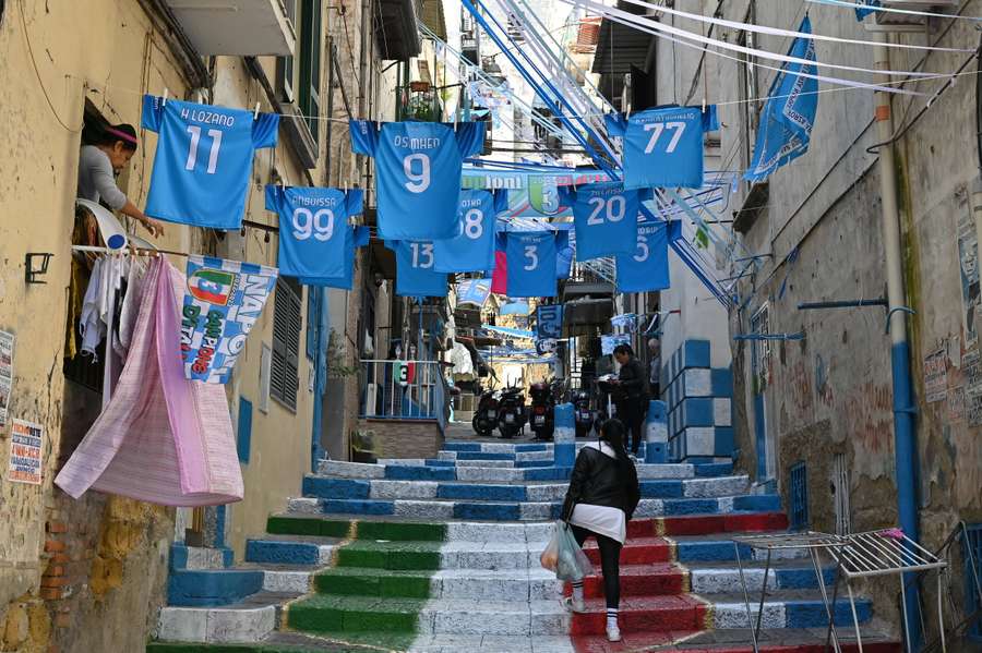 Flags, banners, jerseys with the players' names and a painted stairway decorate the Quartieri Spagnoli district in Naples