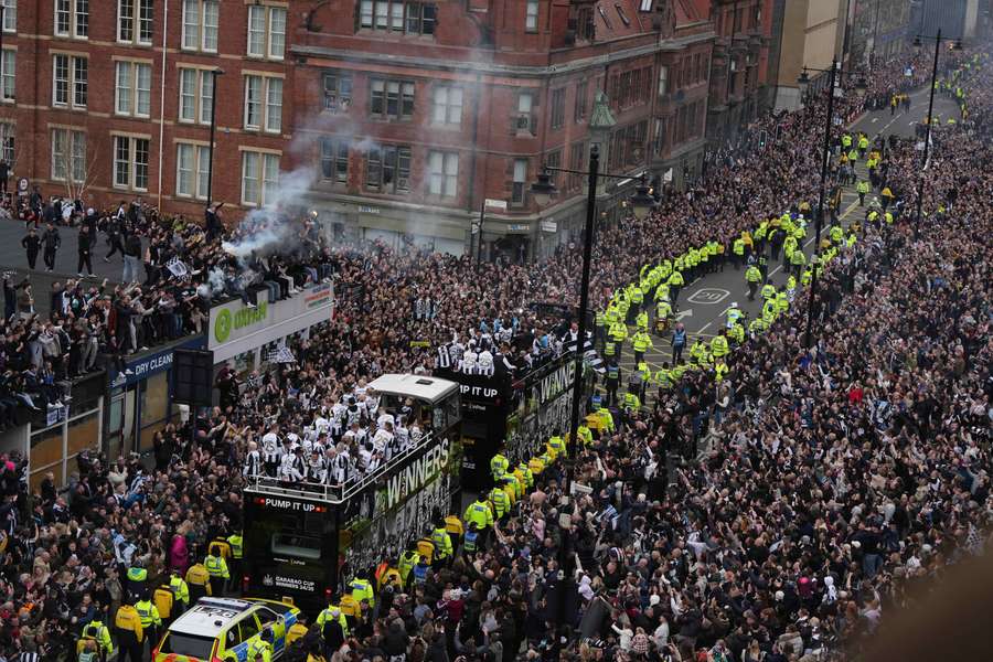 Os jogadores do Newcastle festejam no autocarro durante o desfile da vitória