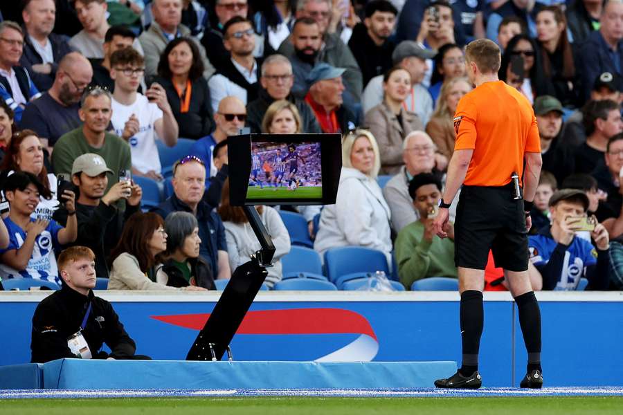 Referee Michael Salisbury checks the VAR monitor after awarding a penalty for a foul on Marc Cucurella of Chelsea