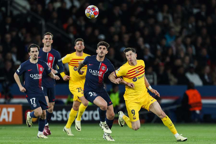 Lucas Beraldo (PSG) rywalizuje z Robertem Lewandowskim z FC Barcelona podczas meczu ćwierćfinałowego Ligi Mistrzów, Francja, 10 kwietnia 2024 r.