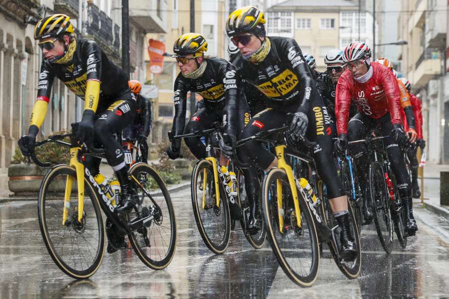 Jonas Vingegaard (L) tijdens de start in Lugo, waar het al beestenweer was