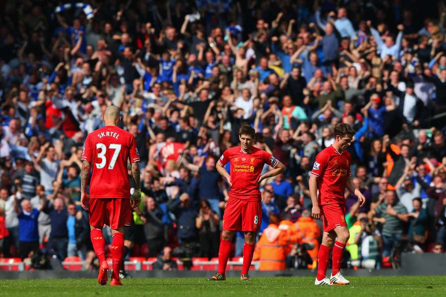 En nedslået Martin Skrtel, Steven Gerrard og Joe Allen fra Liverpool ser på, mens Chelsea-fansene jubler.